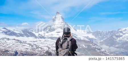 man Tourist Exploring Zermatt, Switzerland. happy hiker sightseeing iconic Matterhorn Swiss Alps Viewpoint, Famous European Landmark, Popular Tourist Attraction and Travel Destination in Europe man Tourist Exploring Zermatt, Switzerland. happy hiker sightseeing iconic Matterhorn Swiss Alps Viewpoint, Famous European Landmark, Popular Tourist Attraction and Travel Destination in Europe 141575865