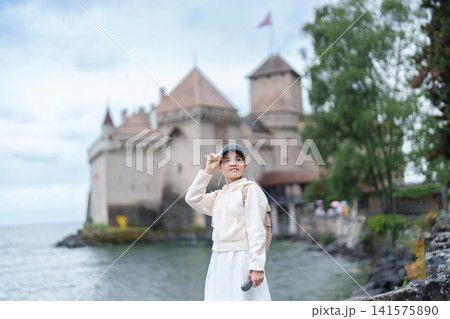 Woman Tourist Explore Chateau de Chillon, Montreux, Switzerland in Summer. Traveler Visit the Historic Medieval Castle on Lake Geneva, Famous European Tourist Attraction and Europe Travel Destination Woman Tourist Explore Chateau de Chillon, Montreux, Switzerland in Summer. Traveler Visit the Historic Medieval Castle on Lake Geneva, Famous European Tourist Attraction and Europe Travel Destination 141575890