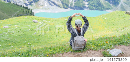 Woman Tourist Explore Oeschinensee, Kandersteg, Switzerland in Summer. Hiker Making Heart Shape at Hiking Trail, Wildflowers and Turquoise Alpine Lake, Popular Europe travel Attraction and Destination Woman Tourist Explore Oeschinensee, Kandersteg, Switzerland in Summer. Hiker Making Heart Shape at Hiking Trail, Wildflowers and Turquoise Alpine Lake, Popular Europe travel Attraction and Destination 141575899