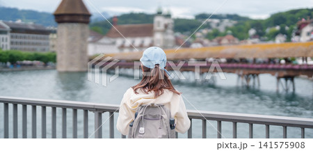 Woman Tourist Explore Lucerne, Switzerland in Summer. Traveler Visit Chapel Bridge and Water Tower on Reuss River. Famous European Landmark, Popular Tourist Attraction and Travel Destination in Europe Woman Tourist Explore Lucerne, Switzerland in Summer. Traveler Visit Chapel Bridge and Water Tower on Reuss River. Famous European Landmark, Popular Tourist Attraction and Travel Destination in Europe 141575908