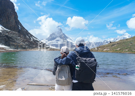 Couple Tourist Exploring Zermatt, Switzerland. happy hiker sightseeing iconic Matterhorn Swiss Alps at Riffelsee Lake, Famous European Landmark, Hiking Attraction and Travel Destination in Europe Couple Tourist Exploring Zermatt, Switzerland. happy hiker sightseeing iconic Matterhorn Swiss Alps at Riffelsee Lake, Famous European Landmark, Hiking Attraction and Travel Destination in Europe 141576016