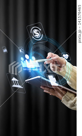 Close-up of a person using a tablet to manage employee benefits through a futuristic glowing hologram interface with financial and healthcare icons. Concept of Corporate wellness program Close-up of a person using a tablet to manage employee benefits through a futuristic glowing hologram interface with financial and healthcare icons. Concept of Corporate wellness program 141576465