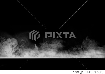 Low-lying white smoke and thick fog drifting across a solid black background. Smoke background Low-lying white smoke and thick fog drifting across a solid black background. Smoke background 141576509