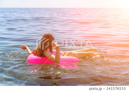 Young woman relaxing floating bright pink inflatable ring calm blue ocean water summer vacation travel copy space 141576533