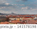 Historic Prague Rooftops with Prague Castle Beneath Dramatic Spring Clouds at Sunset 141578198