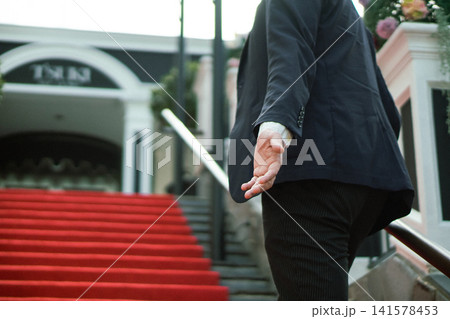 レッドカーペットの階段で恋人の手を取ろうとする男性 婚活、デート、バチェラー、恋愛リアリティショー レッドカーペットの階段で恋人の手を取ろうとする男性 婚活、デート、バチェラー、恋愛リアリティショー 141578453