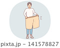 Lost weight man with big shorts in hands is surprised at size of own clothes from past 141578827
