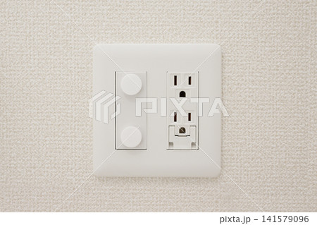 壁に取り付けられた白い電源コンセントとスイッチパネル 壁に取り付けられた白い電源コンセントとスイッチパネル 141579096