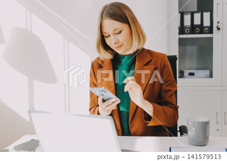 Woman smiling to herself as she works in an office 141579513