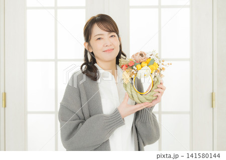 しめ縄リースを持つ笑顔の女性 しめ縄リースを持つ笑顔の女性 141580144