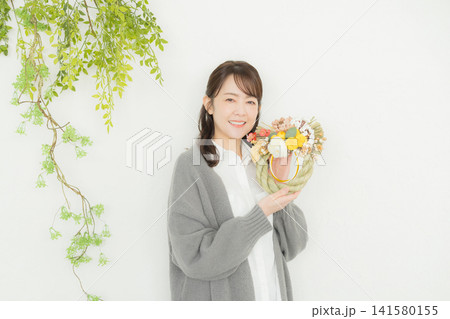 しめ縄リースを持つ笑顔の女性 しめ縄リースを持つ笑顔の女性 141580155