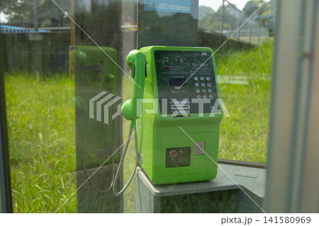 緑の公衆電話をガラス越しに見ている 緑の公衆電話をガラス越しに見ている 141580969