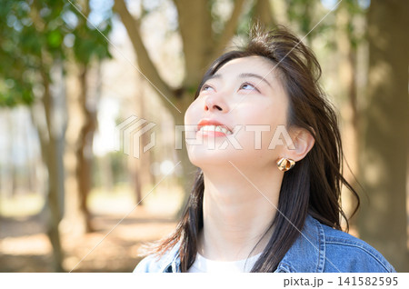 公園で深呼吸してリラックスする日本人女性 公園で深呼吸してリラックスする日本人女性 141582595