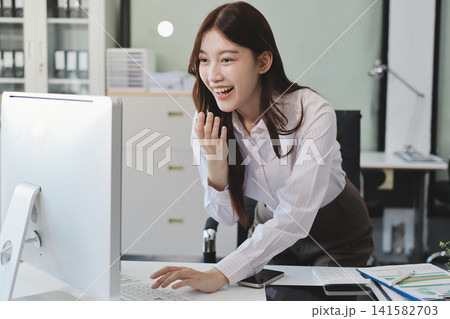Young businesswoman professional employee using pc doing online banking analysing at workplace. Asian middle-aged business woman working on laptop computer in office, taking notes. Banner, copy space Young businesswoman professional employee using pc doing online banking analysing at workplace. Asian middle-aged business woman working on laptop computer in office, taking notes. Banner, copy space 141582703