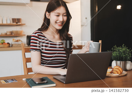 Asian woman using computer remote for business studying, watching online virtual webinar training meeting, video call. asian business woman talking on laptop in home office. Banner, copy space 141582730