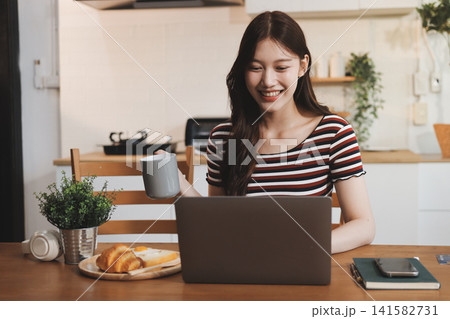 Asian woman using computer remote for business studying, watching online virtual webinar training meeting, video call. asian business woman talking on laptop in home office. Banner, copy space Asian woman using computer remote for business studying, watching online virtual webinar training meeting, video call. asian business woman talking on laptop in home office. Banner, copy space 141582731