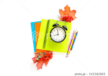 Colorful school supplies, book, and alarm clock on white. Colorful school supplies, book, and alarm clock on white. 141582803
