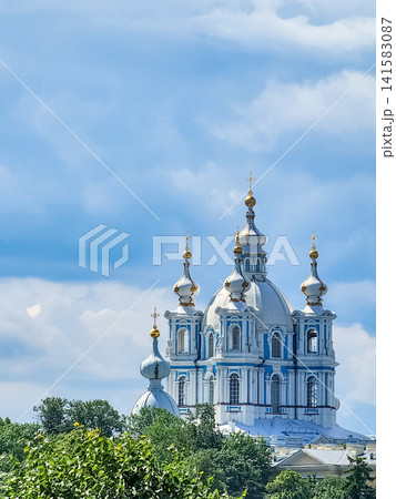 Smolny Cathedral domes with gold crosses rising above trees against a blue sky in Saint Petersburg, Russia Smolny Cathedral domes with gold crosses rising above trees against a blue sky in Saint Petersburg, Russia 141583087