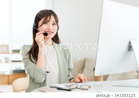コールセンターで電話対応するオペレーターの女性 コールセンターで電話対応するオペレーターの女性 141583125