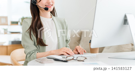 コールセンターで電話対応するオペレーターの女性 コールセンターで電話対応するオペレーターの女性 141583127