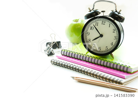 Colorful school supplies, book and alarm clock on white. Back to school. Colorful school supplies, book and alarm clock on white. Back to school. 141583390