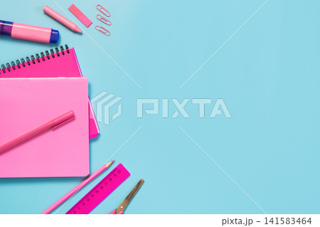 Pink girlish school supplies, notebooks and pens on punchy blue. Pink girlish school supplies, notebooks and pens on punchy blue. 141583464