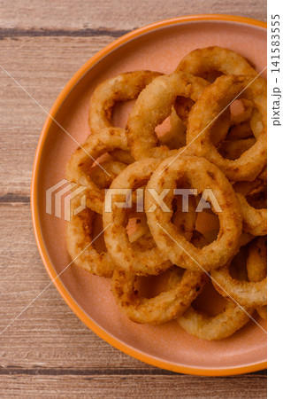 Deep fried breaded onion or squid rings, crispy fast food snacks. Fried onion or squid rings Deep fried breaded onion or squid rings, crispy fast food snacks. Fried onion or squid rings 141583555