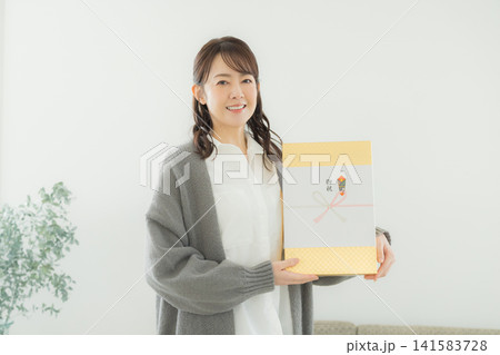 のし紙のついたギフトを渡す女性 のし紙のついたギフトを渡す女性 141583728
