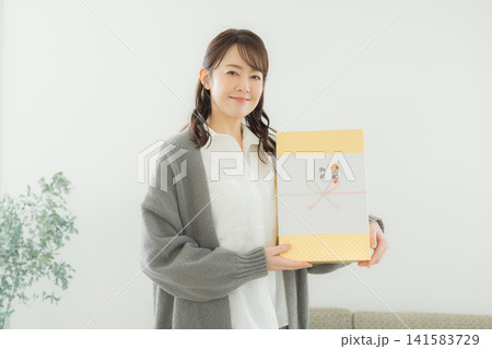 のし紙のついたギフトを渡す女性 のし紙のついたギフトを渡す女性 141583729