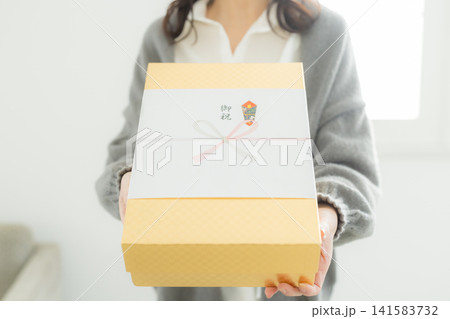 のし紙のついたギフトを渡す女性 のし紙のついたギフトを渡す女性 141583732