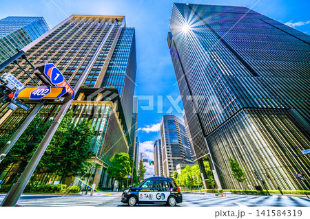 日本の東京都市景観7月19日。「大手町駅前」交差点から大手町などのビジネス街やタクシーを望む 日本の東京都市景観7月19日。「大手町駅前」交差点から大手町などのビジネス街やタクシーを望む 141584319