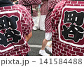 お祭りで揃いのレンガ模様の法被(はっぴ)を着た人々の後ろ姿 お祭りで揃いのレンガ模様の法被(はっぴ)を着た人々の後ろ姿 141584488