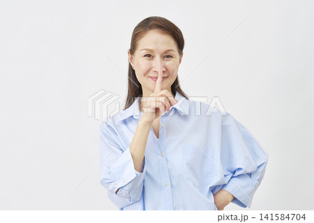 白背景で内緒のジェスチャーをする女性 白背景で内緒のジェスチャーをする女性 141584704