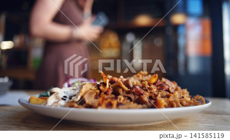 Large Plate Of Sliced Grilled Kebab With Vegetables, Girl Selects Order Near The Bar Counter 141585119