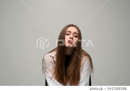 Young woman feeling sad and tired, showing depression, loneliness, or mental health issues, with a melancholic expression Young woman feeling sad and tired, showing depression, loneliness, or mental health issues, with a melancholic expression 141588586