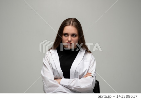 Moody young woman with crossed arms pouting and looking away, expressing stubbornness, resentment, and annoyance Moody young woman with crossed arms pouting and looking away, expressing stubbornness, resentment, and annoyance 141588617