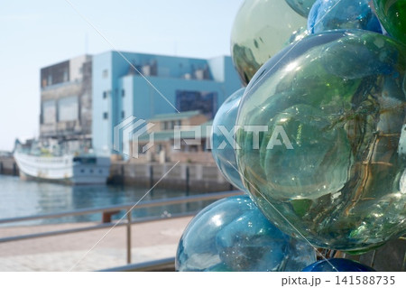 港に並べられたビン玉と漁具の海辺風景 港に並べられたビン玉と漁具の海辺風景 141588735
