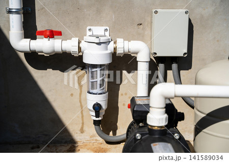 Water filtration system with pump and pressure tank on concrete wall Water filtration system with pump and pressure tank on concrete wall 141589034