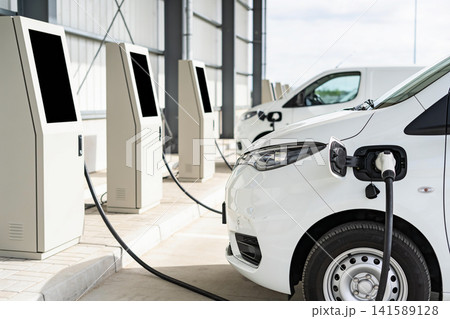 Electric vehicles charging at modern charging stations on a sunny day Electric vehicles charging at modern charging stations on a sunny day 141589128