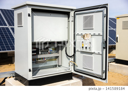 Outdoor electrical control cabinet with solar panels in the background 141589184