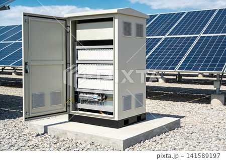 Solar power station electrical control cabinet with rows of components and solar panels 141589197