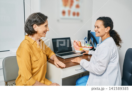 Consultation with experienced female audiologist to mature woman patient at medical clinic. Treatment of hearing loss in senior people 141589385