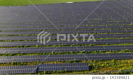 Solar farm generating clean electricity with rows of solar panels providing sustainable energy in a green field Solar farm generating clean electricity with rows of solar panels providing sustainable energy in a green field 141589821