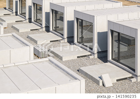 Modern modular construction site with concrete foundations and building elements Modern modular construction site with concrete foundations and building elements 141590235