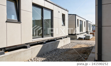 Modular construction site with modern prefabricated buildings on concrete foundations Modular construction site with modern prefabricated buildings on concrete foundations 141590252