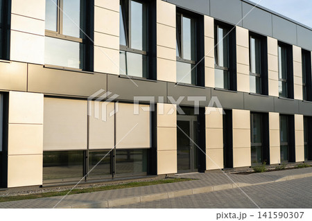 Modern office building facade with large windows and beige paneling 141590307