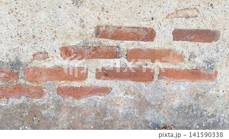 Weathered Concrete Wall with Exposed Red Bricks Weathered Concrete Wall with Exposed Red Bricks 141590338