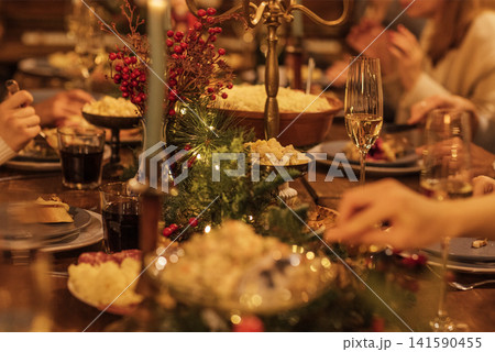 Festive dining table adorned with seasonal decorations, featuring delicious dishes, sparkling glasses, and warm candlelight, creating a cozy holiday atmosphere for gathering and celebration Festive dining table adorned with seasonal decorations, featuring delicious dishes, sparkling glasses, and warm candlelight, creating a cozy holiday atmosphere for gathering and celebration 141590455