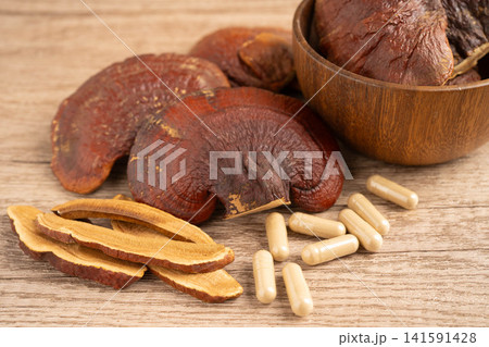 Lingzhi or Reishi mushroom with capsules, organic natural healthy food. Lingzhi or Reishi mushroom with capsules, organic natural healthy food. 141591428