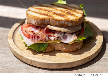 Grilled club sandwich with bacon, ham and turkey 141591530